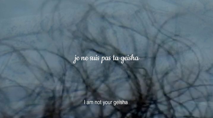 The image features an extreme close-up of tangled strands of brown hair on a background of dull cool blue. Cursive text in the middle of the frame reads "je ne suis pas ta geisha", and at the bottom of the screen is normal text reading "i am not your geisha".
