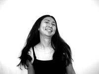 Black and white photo of Gein Wong. They have long black hair, are of First Nation and Asian descent, and appear to be in motion.