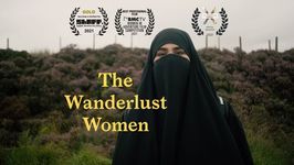 There are purple bushes in the background with a person in the front. The person is wearing a black niqab with a black backpack on their back. The film's title, "The Wanderlust Women," is imposed in yellow in a serif font on the middle-left of the image. Symbols for several awards which the film has achieved adorn the top of the image.