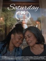 Two people rest their heads against each other in front of a window. The one on the left has brown skin and black dreadlocks in a half up half down updo. They are wearing a gray t-shirt with a gold necklace and a denim jacket.The person on the right has light brown skin with a bob haircut with gray roots and black ends. They are wearing a silver necklace a black and gray checkered shirt.