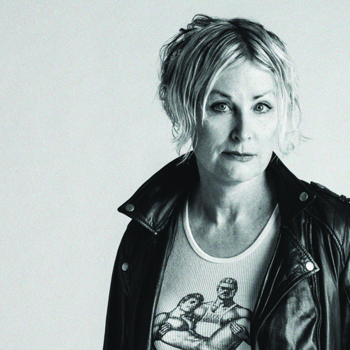 Picture of Shawna Virago, a blonde woman in a white tank and a black leather jacket.